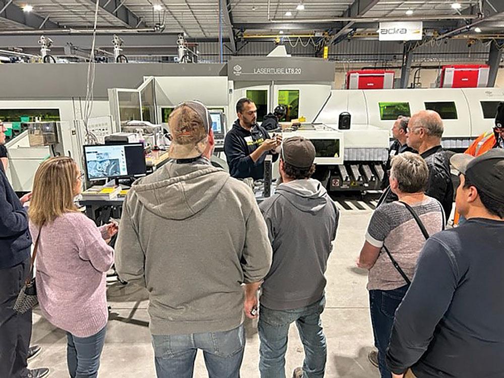 A crowd of people gather in front of the company’s new tube cutting laser.  