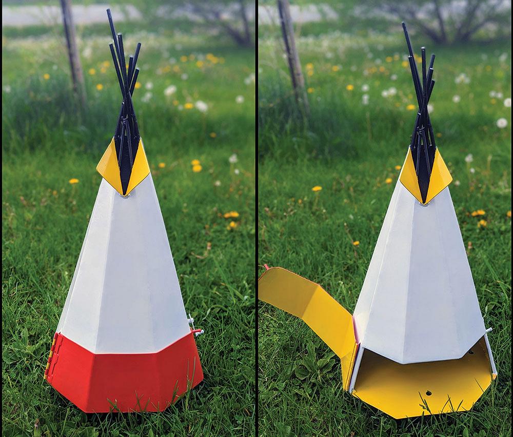 Two tipi-shaped bug smokers sit on a lawn. 