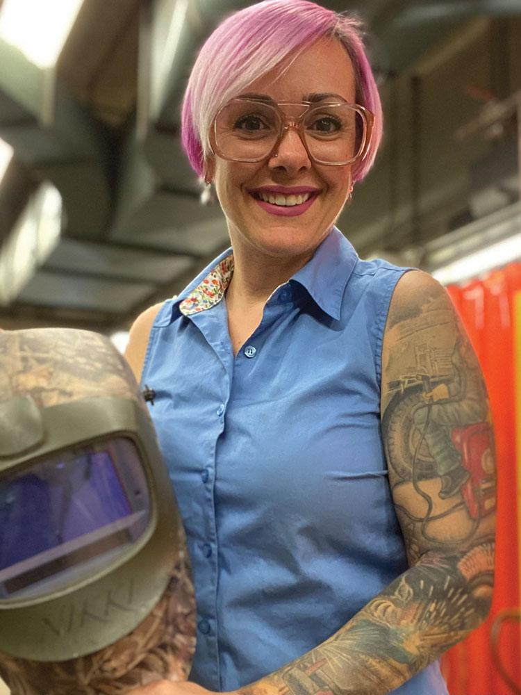 Nikki Noble, Lambton College, holding a welding helmet. 