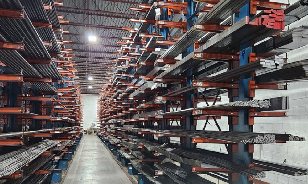 Shelves of steel products stand on left and right of an aisle. 