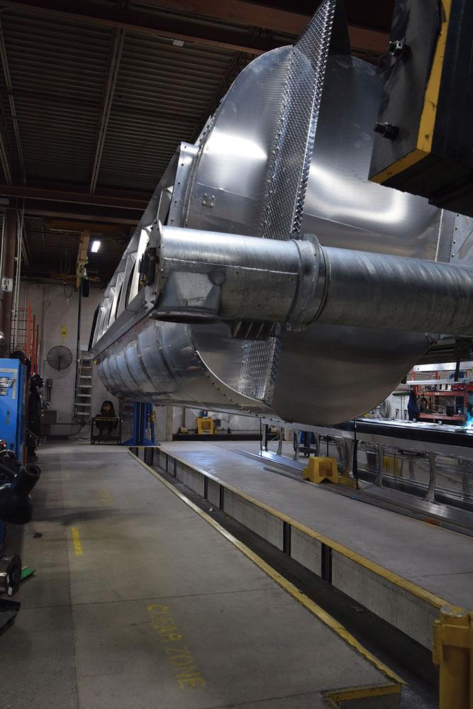 Part of a feed trailer hangs above the ground making it easier for employees to work on it.