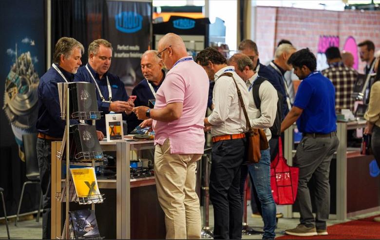 Attendees standing at a booth at FABTECH Canada
