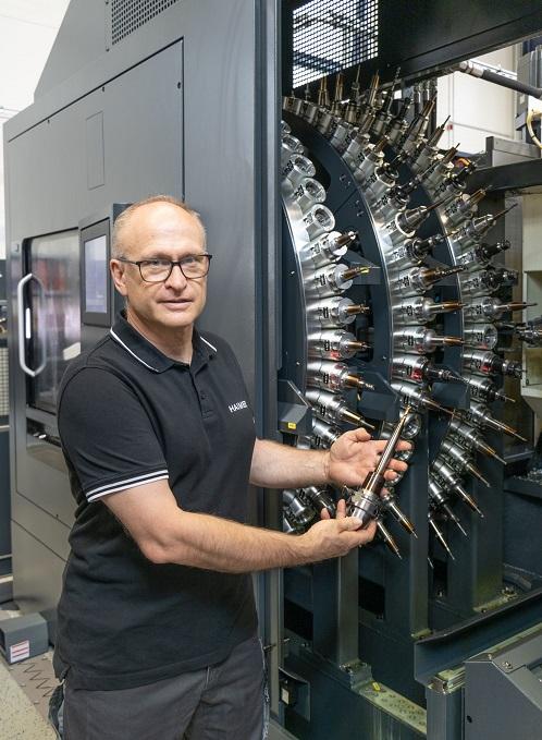 Manfred Mayr stands in front of machine tools.
