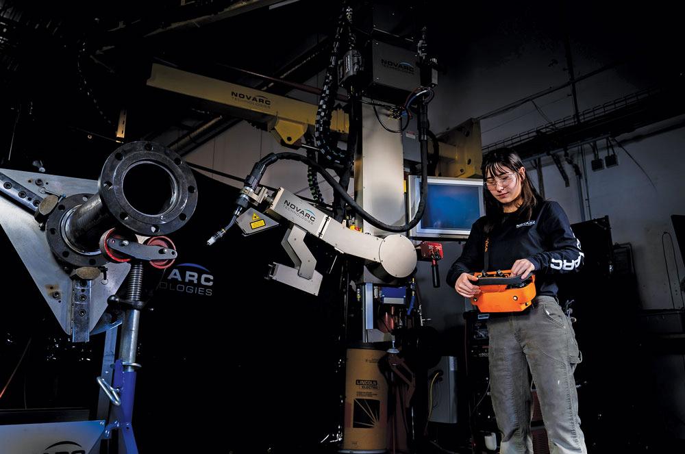 An operator uses a Novarc spool welding robot (SWR).