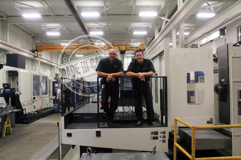 Brian Bendig and Mike McNaughton stand on a machine access platform