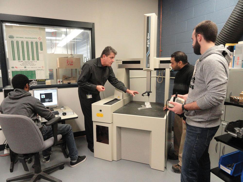 Centennial College Instructor Lucian Toma with students and CMM.