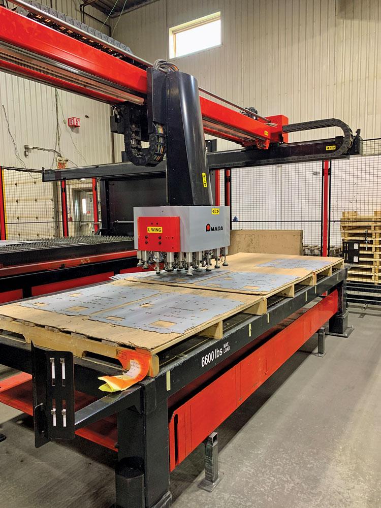 Amada's TK 3015 automated parts sorter places finished metal cut parts on worktable.