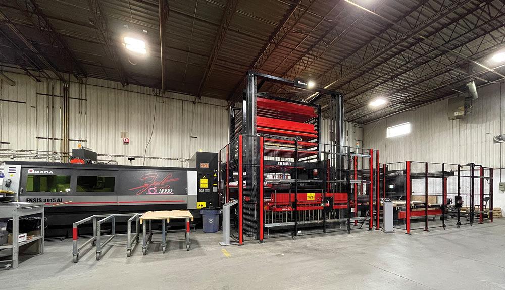 Picture shows a fiber laser, storage tower, and part sorter on a shop floor. 