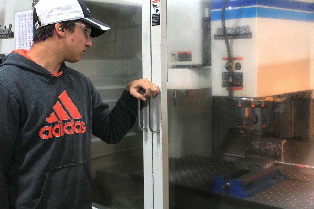 Student Mason Oullette works on a CNC mill.