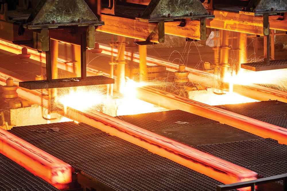 Hot steel sits on conveyor in a steel mill.