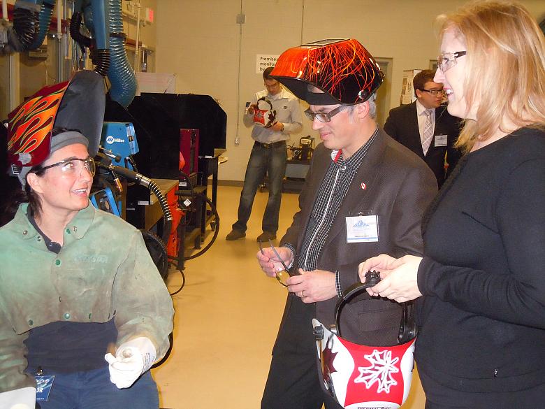 Ministers Tony Clement (R) and Lisa Raitt (L) have the finer points of welding explained to them (Photo: CWB)