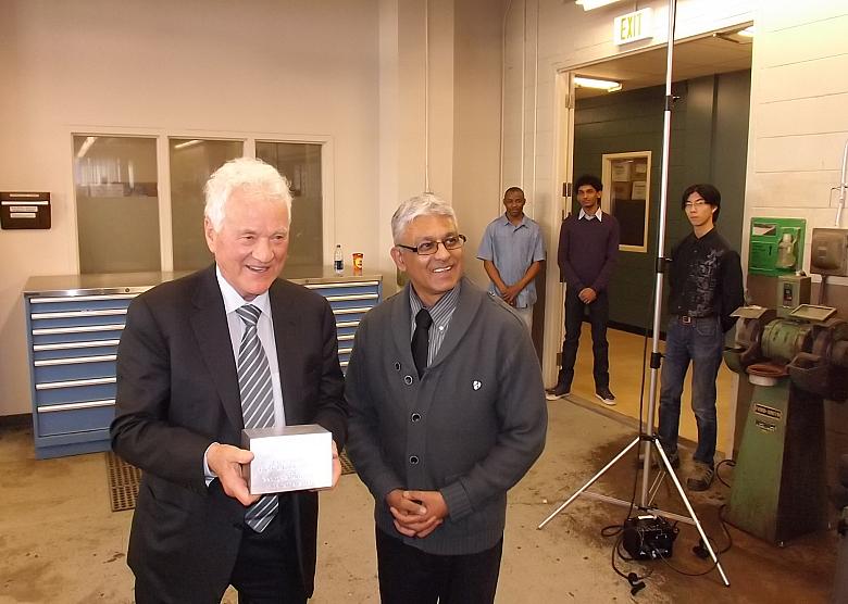 Stronach is presented with an engraved aluminum cube. (Photo: Jim Anderton/Canadian Metalworking)
