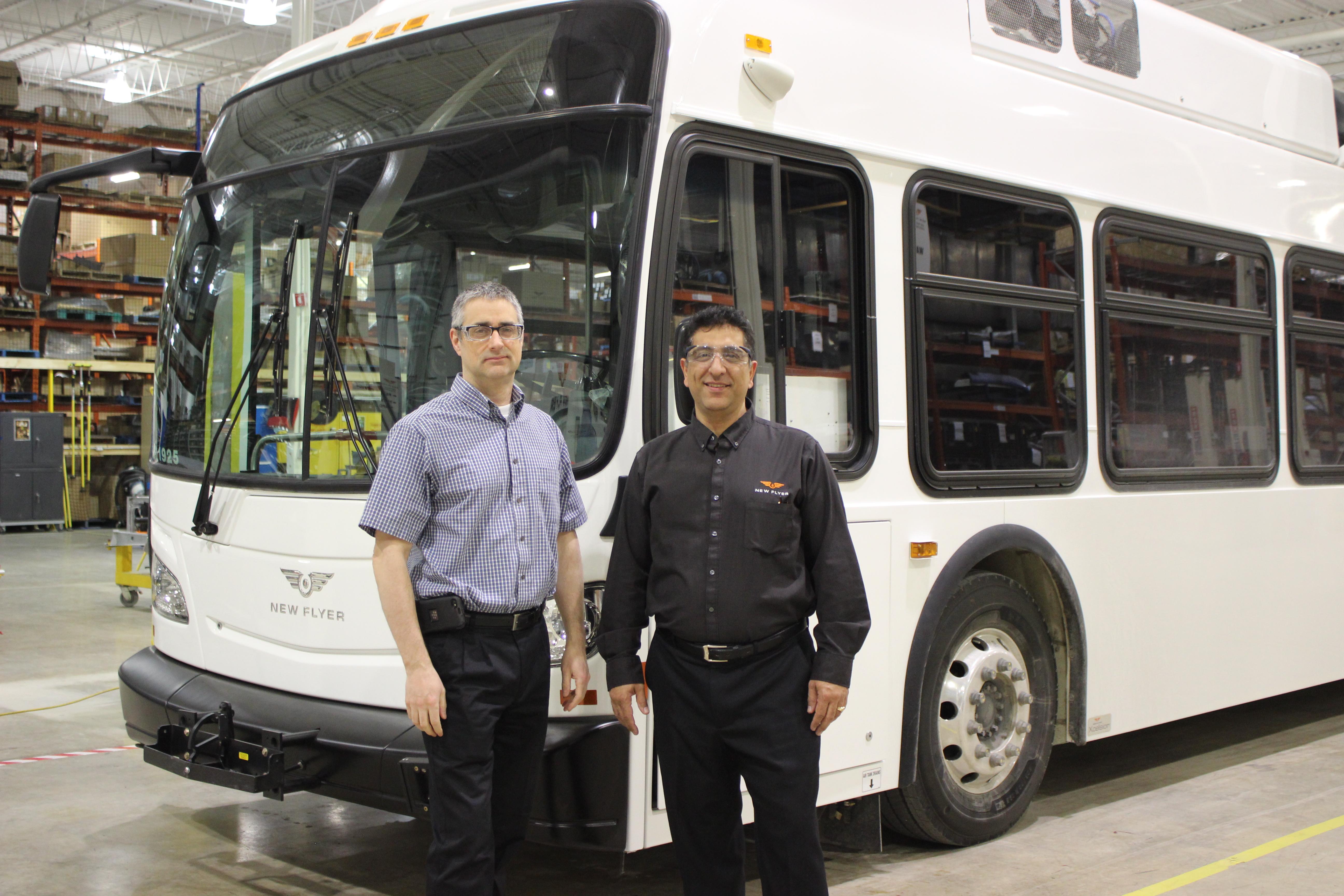 精益企业经理Jim Tingley与温尼伯工厂经理Shane Zaeneli在新的传单建造的电动公共汽车前面。照片由Shayla McFadyen，由新的传单行业提供。