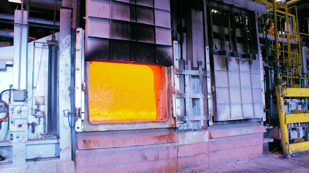 The open furnace doors show the molten aluminum.