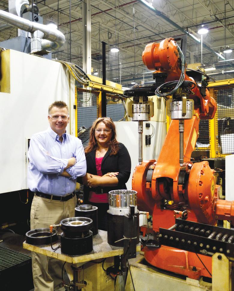 Linamar Gear&rsquo;s Craig Ferneyhough, general manager, and Ania Kreft, quality manager, pose with transmission parts and assemblies by one of the shop&rsquo;s robotic welding machines.