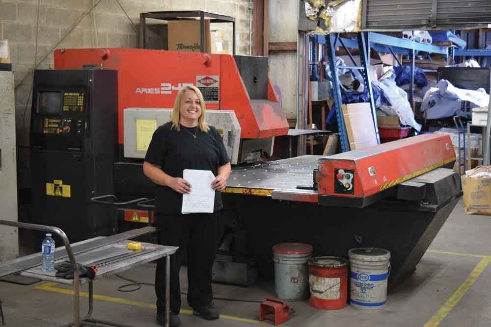 Lisa Oster in front of the shop’s Amada Aries 245, which is situated right next to the new Apex deburring machine for the rapid processing of parts. 