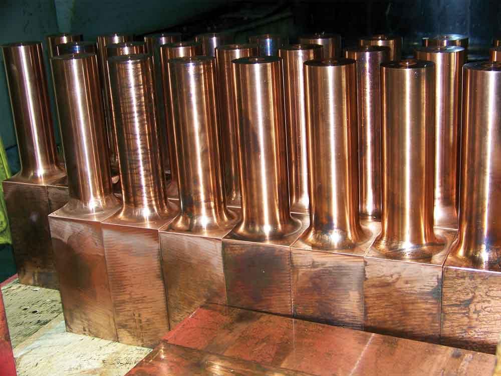 Copper adaptor blocks used on aluminum gun arm for robotic welding are ready for secondary machining.