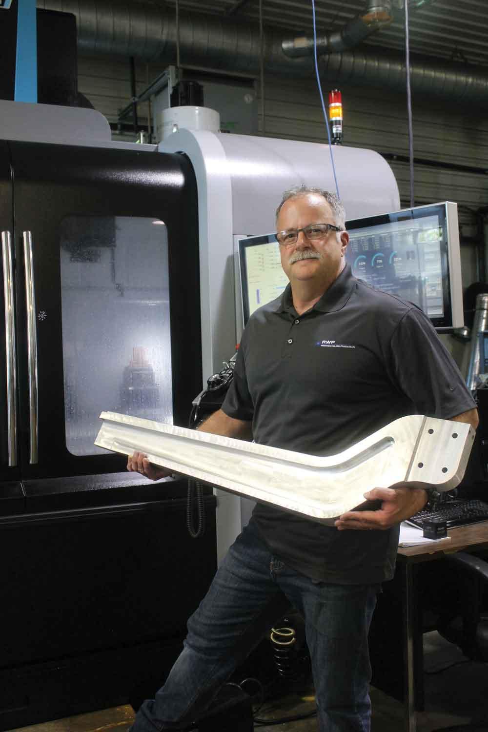 Alan McGuigan，抵抗焊接产品有限公司的运营经理在Blenheim，Ont，持有一个用于机器人焊机的铝臂。照片由James Gervais。