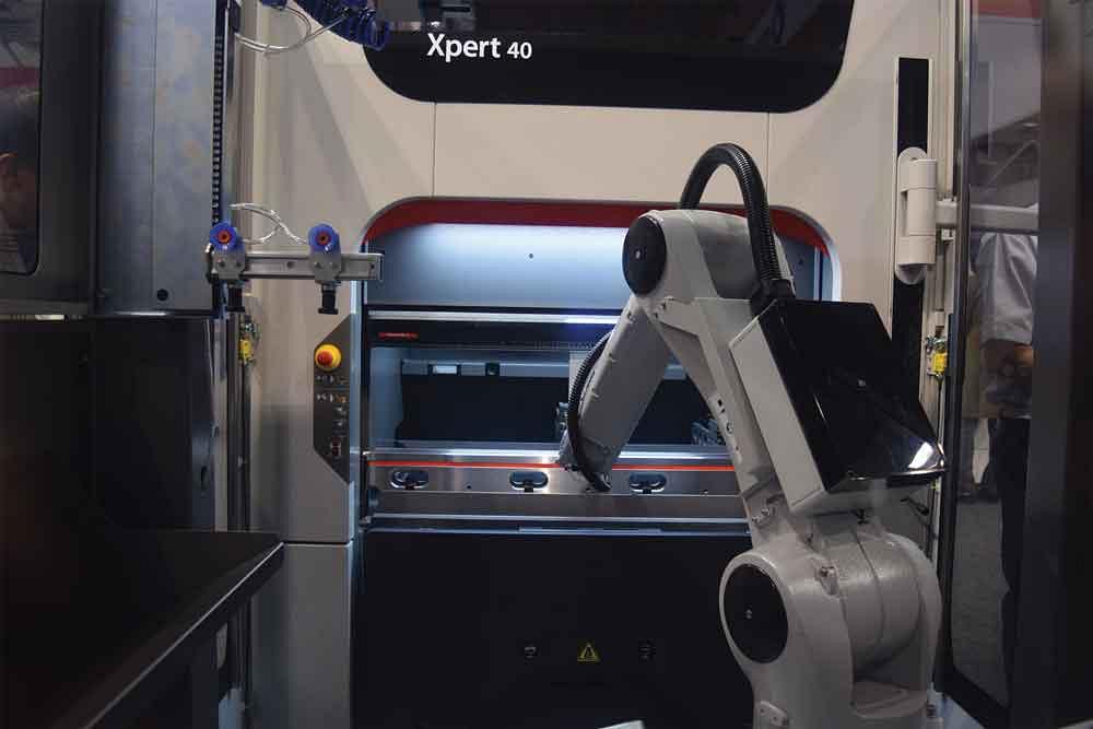 A robot is placed in front of an Xpert 40 press brake from Bystronic to demonstrate the flexibility of the bending cell. After a large, repetitive bending job is done, the robot can be moved, and the press brake can be used for manual operations.