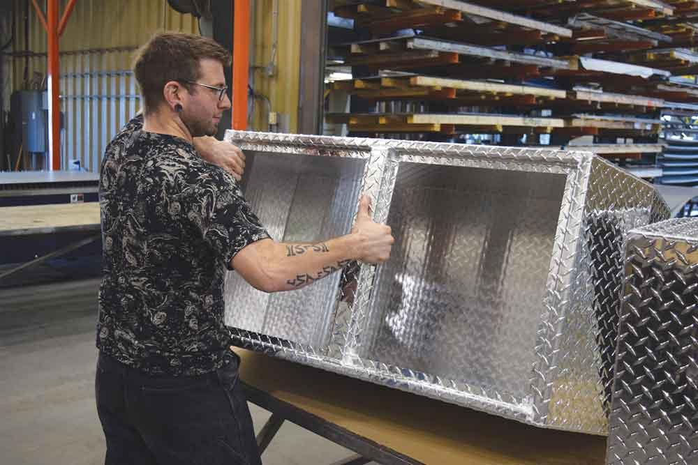 Programmer Randy Mullin with a diamond plate assembly on the shop floor. 