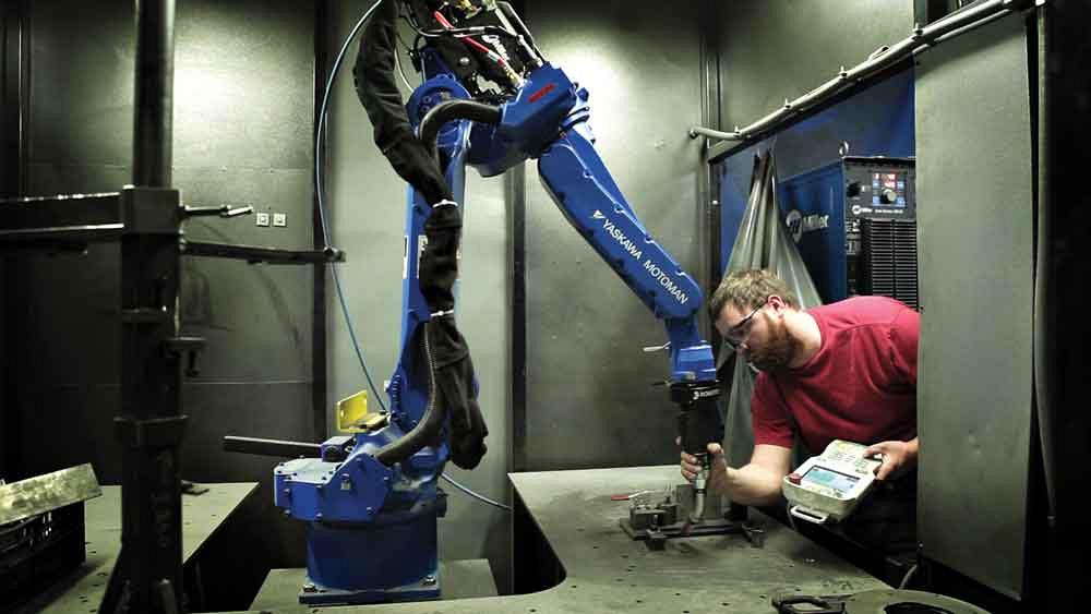 Yaskawa Motoman has introduced the Kinetiq simplified teaching system, originally developed by Quebec-based Robotiq. This system uses lead-through programming, meaning you hand-guide the robot, as shown here. Image courtesy Yaskawa Motoman. 